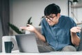 Confused clueless man using laptop computer for Video conference call shrugging shoulders making no idea, whatever gesture I don` Royalty Free Stock Photo