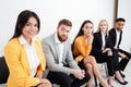 Confused colleagues sitting in office looking at cheerful woman. Royalty Free Stock Photo