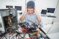 Confused computer engineer working on broken console with laptop Royalty Free Stock Photo