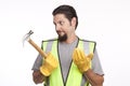 Confused construction worker holding a hammer
