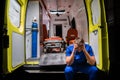 Confused corpsman in blue uniform sit on the ambulance car