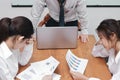 Confused depressed young Asian business people suffering from severe problem between meeting in conference room.