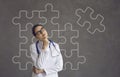 Confused doctor thinking of solution to problem on background with incomplete jigsaw puzzle Royalty Free Stock Photo