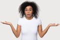 Confused doubtful baffled black woman shrugging looking at camera