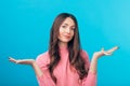 Confused doubtful woman isolated on blue background