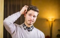 Confused or doubtful young man scratching his head and looking up Royalty Free Stock Photo