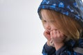 Confused Dreaming little girl dressed for winter hold hands under chin