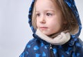 Confused Dreaming little girl dressed for winter with hood and scarves