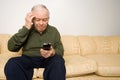 Confused elderly man with remote control Royalty Free Stock Photo