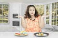 Confused fat woman eats in the kitchen Royalty Free Stock Photo