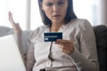 Confused female customer holding credit card angry with online payment Royalty Free Stock Photo