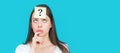 Confused female thinking with question mark on sticky note on forehead. Thinking woman with question mark looking up