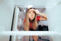 Confused Girl Looking into Her Empty Refrigerator Royalty Free Stock Photo