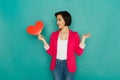 Confused girl with paper heart at studio background Royalty Free Stock Photo