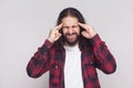 Confused handsome man with beard and black long curly hair in ca Royalty Free Stock Photo