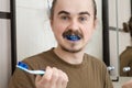 Confused man about colored tooth brush Royalty Free Stock Photo