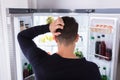 Confused Man Looking At Food In Refrigerator Royalty Free Stock Photo