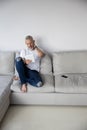 Confused man in ragged jeans staring at a tablet Royalty Free Stock Photo