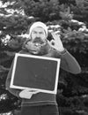 Confused santa with blank chalkboard gives ok gesture on winter day