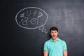 Confused man thinking about problem with blackboard behind him Royalty Free Stock Photo