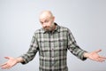 Confused mature bearded man standing and shrugging shoulders isolated over white background. Royalty Free Stock Photo