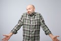 Confused mature bearded man standing and shrugging shoulders isolated over white background. Royalty Free Stock Photo