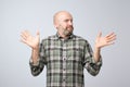 Confused mature bearded man standing and shrugging shoulders isolated over white background. Royalty Free Stock Photo