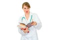 Confused medical female doctor with pile of books Royalty Free Stock Photo