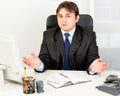 Confused modern business man sitting at desk