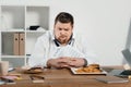 confused overweight businessman choosing donuts or hamburger with french Royalty Free Stock Photo