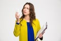 Confused pretty young woman holding folders and using smartphone Royalty Free Stock Photo