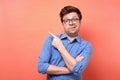 Confused puzzled man in glasses and blue shirt pointing finger aside Royalty Free Stock Photo