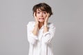 Confused puzzled young business woman in white shirt posing isolated on grey wall background studio portrait Royalty Free Stock Photo