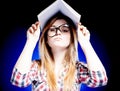 Confused and puzzled young girl holding exercise book on her head Royalty Free Stock Photo