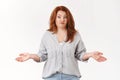 Confused redhead middle-aged shrugging woman spread hands sideways smirking wondered raise eyebrows puzzled have no idea Royalty Free Stock Photo