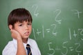 Confused schoolboy thinking while scratching the back of his hea Royalty Free Stock Photo