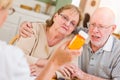 Confused Senior Adult Couple Consult with Doctor or Nurse Explaining Prescription Medicine Royalty Free Stock Photo