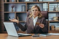 Confused senior businesswoman with credit card at workplace in office Royalty Free Stock Photo