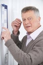 Confused Senior Man With Dementia Looking At Wall Calendar