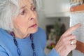 Confused Senior Woman With Dementia Looking At Wall Calendar