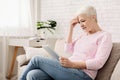 Confused senior woman using tablet computer at home Royalty Free Stock Photo