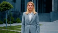 Confused serious pensive puzzled businesswoman standing outdoors spreads arms shrugs unsure caucasian woman doesn't