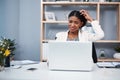 Confused, stressed and angry business woman reading email and scratching her head thinking in her office. A young Royalty Free Stock Photo