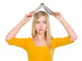 Confused student girl with raised book over head Royalty Free Stock Photo