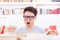Confused student with glasses surrounded by books Royalty Free Stock Photo
