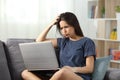 Confused teen reading online content at home