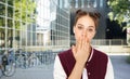 confused teenage girl covering mouth by hand Royalty Free Stock Photo