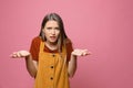 Confused teenage girl on pink background