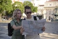 Confused tourist couple with map