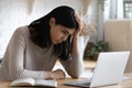 Confused unhappy young korean asian woman looking at laptop screen.